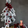 nowoczesny oryginalny stroik choinka ubrana na biało na czerwono na drewnianej podstawie ubrana ozdobiona dekoracja bożonarodzeniowa świąteczna