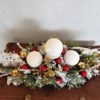 Nowoczesna dekoracja bożonarodzeniowa stroik świąteczny ośnieżony udekorowany bombkami ubrany w kolory złota czerwieni bieli ozdoba na stół wigilijny