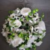 wianek na drzwi wejściowe z białych sztucznych kwiatów z zielonymi dodatkami